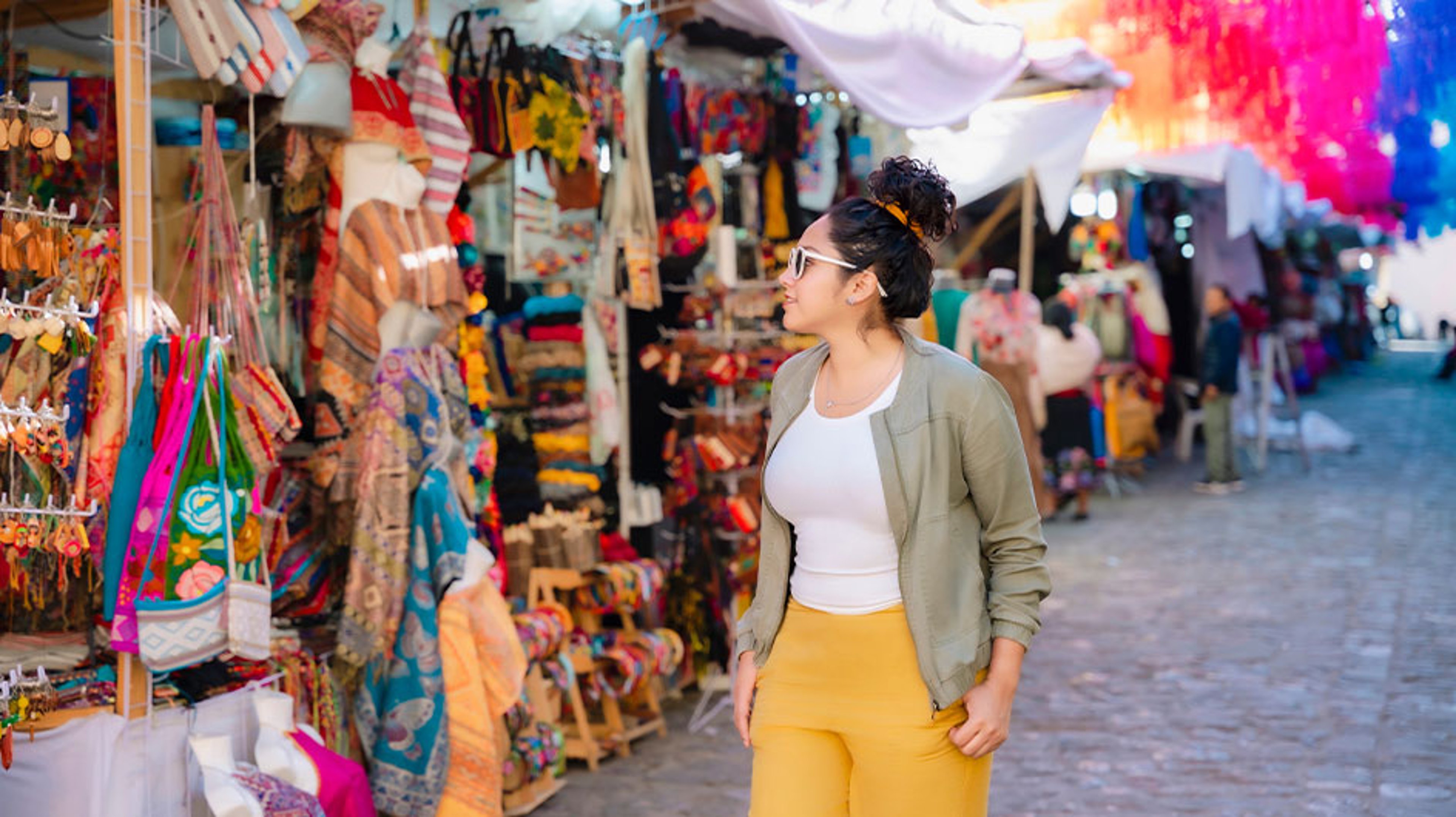 Young Latina woman browsing market stalls in the historic center of Oaxaca, Mexico. 
