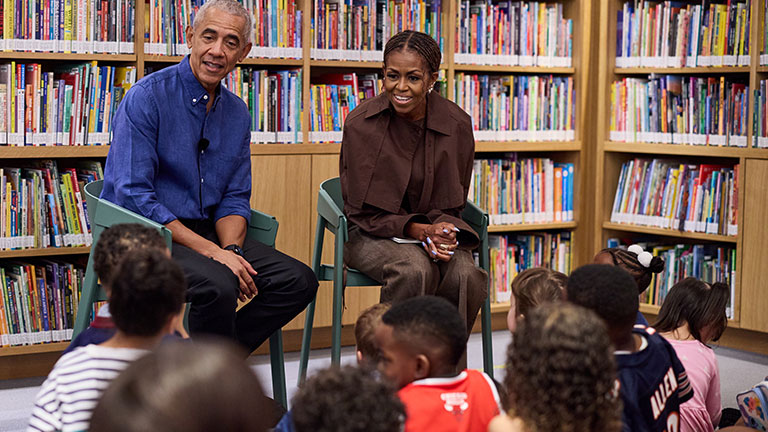 Barack and Michelle Obama speaking with children during a library event at the Obama Presidential Center
