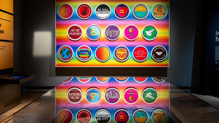 Colorful display of civic and social justice-themed buttons at the Obama Presidential Center museum.
