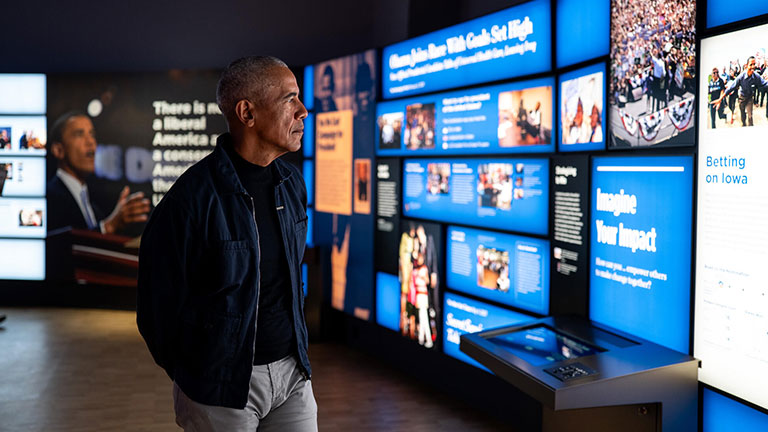 Barack Obama viewing interactive exhibits inside the Obama Presidential Center museum