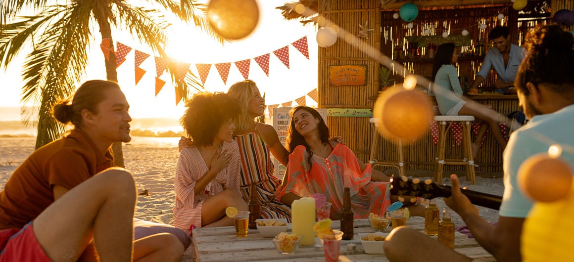 People sitting on beach near outdoor bar