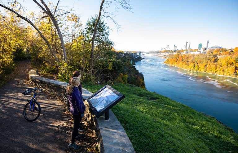 woman on Gorge Trail with bike, reading sign