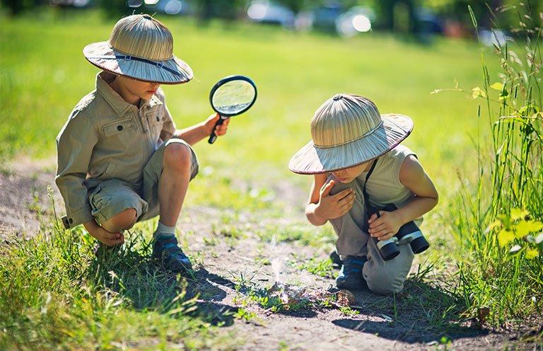 two kids dressed in ranger costumes exploring