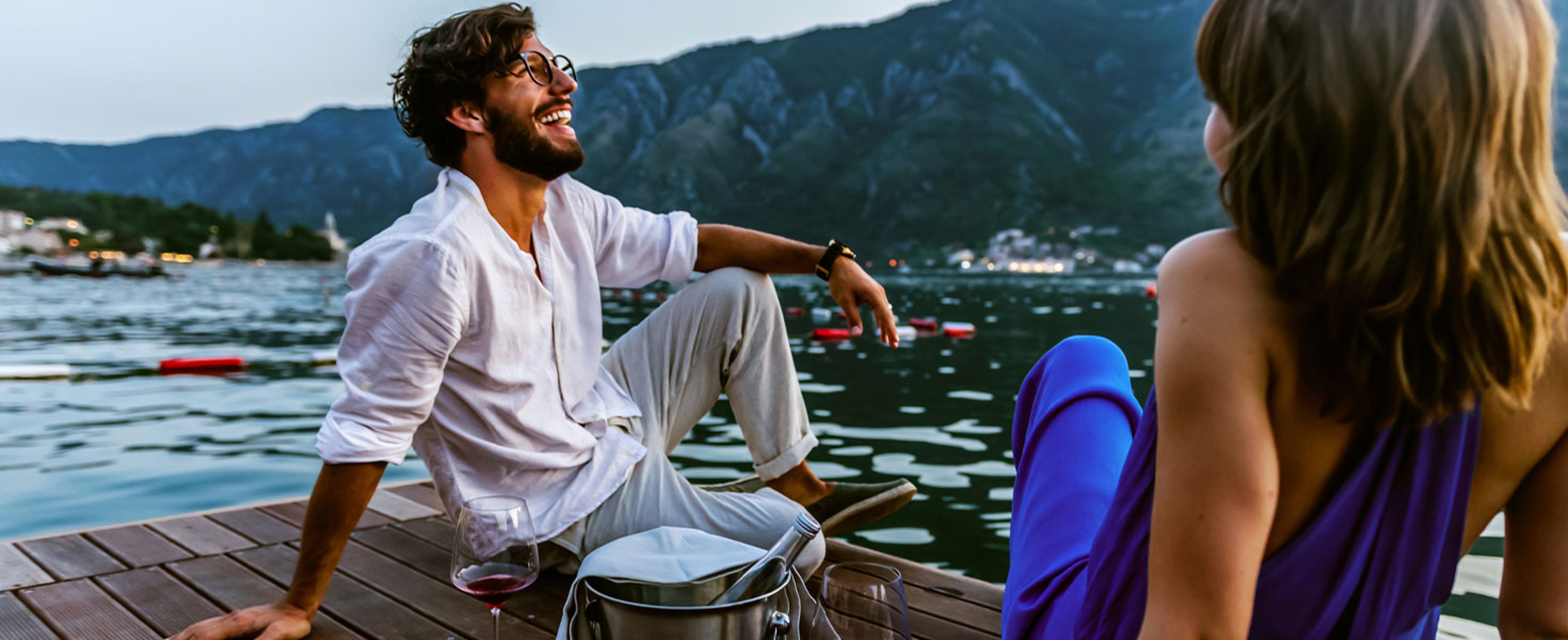 A couple enjoying wine on deck, overlooking water