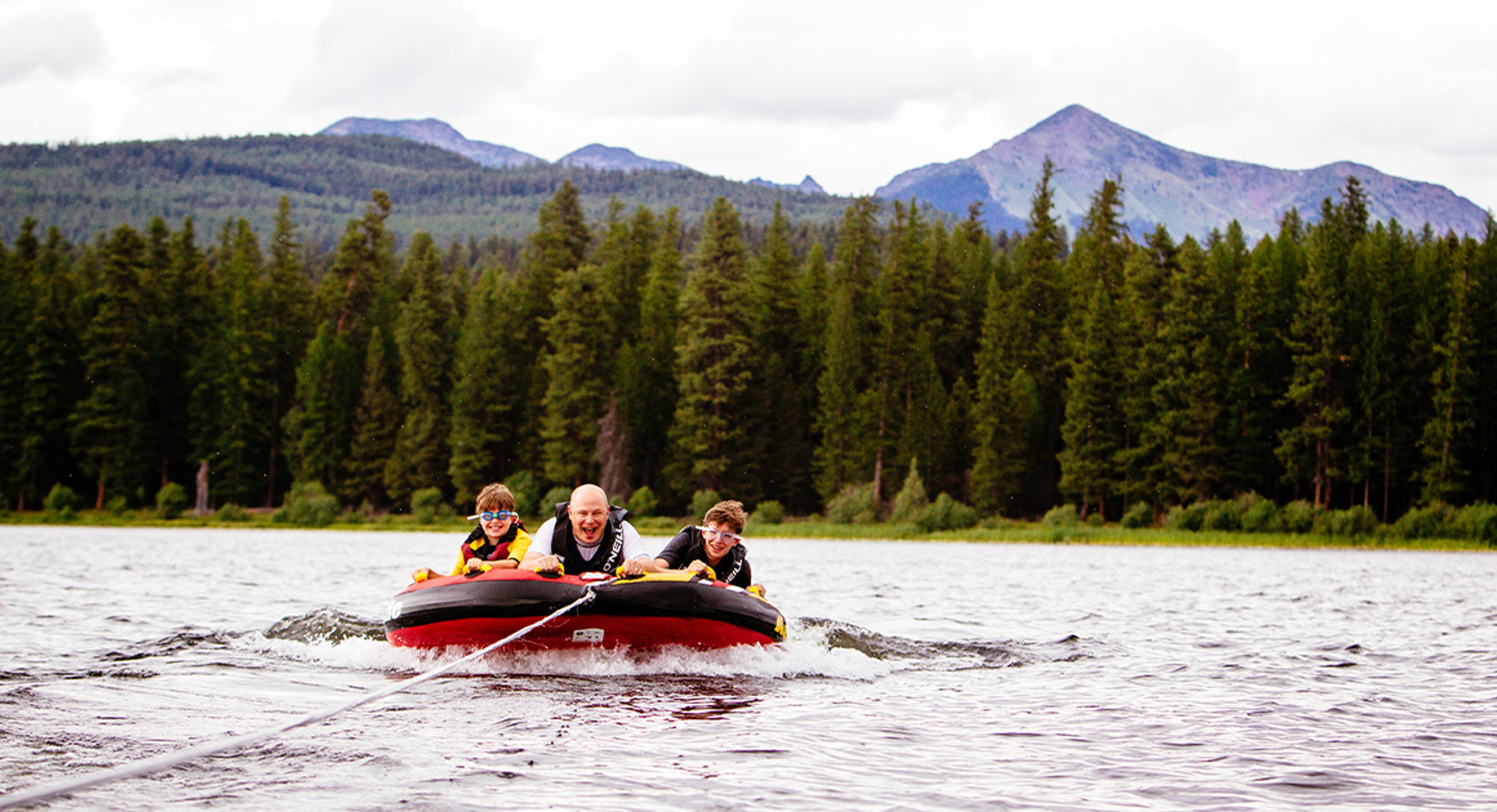 dad and kids on water raft