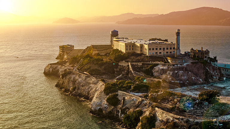 Aerial view of Alcatraz Island and the historic prison in San Francisco Bay at sunset