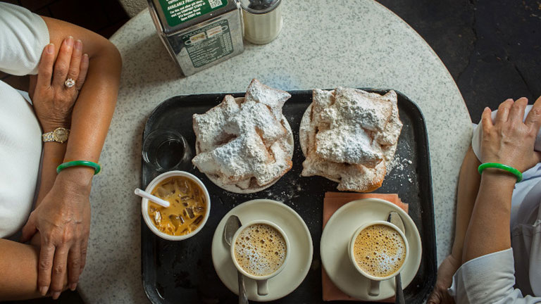 Plate of powdered sugar-covered beignets served at a New Orleans café.