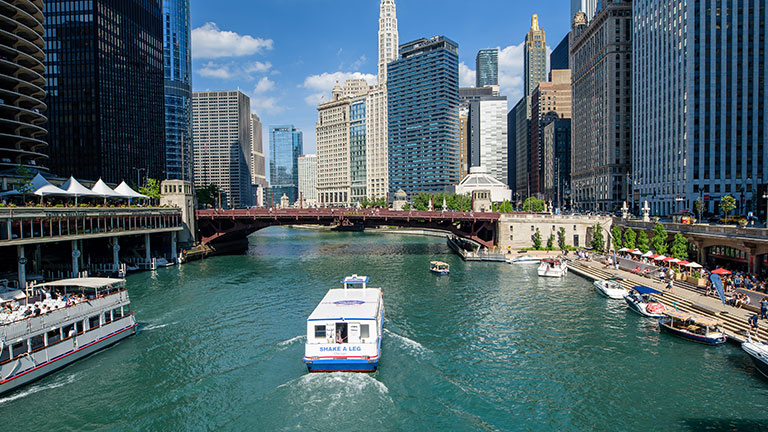 Passengers enjoying a Chicago River architecture cruise with the city skyline in the background.