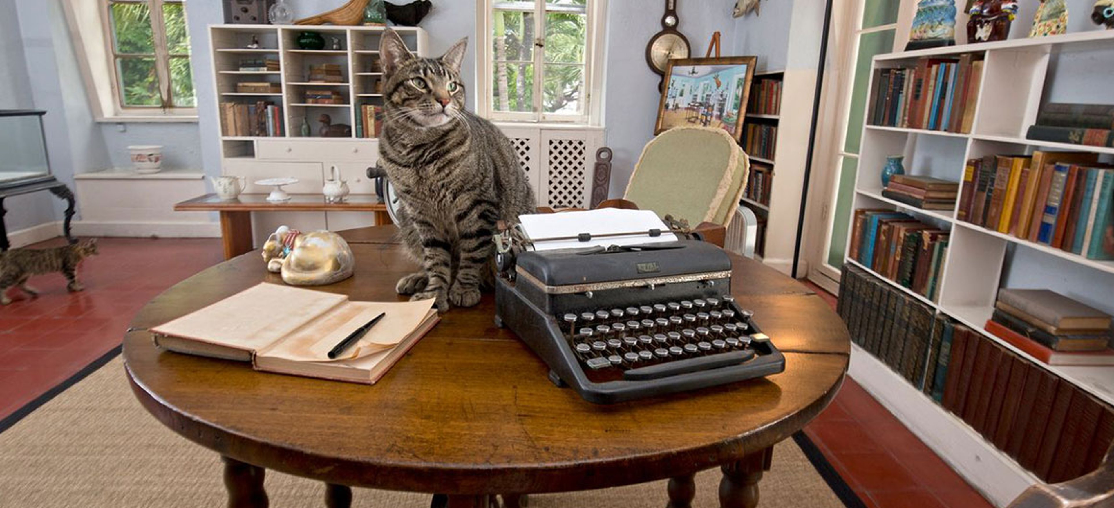 A cat sits beside Ernest Hemingway's typewriter in the writing studio at the Ernest Hemingway Home in Key West.