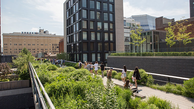 People strolling along the landscaped High Line park in New York City.
