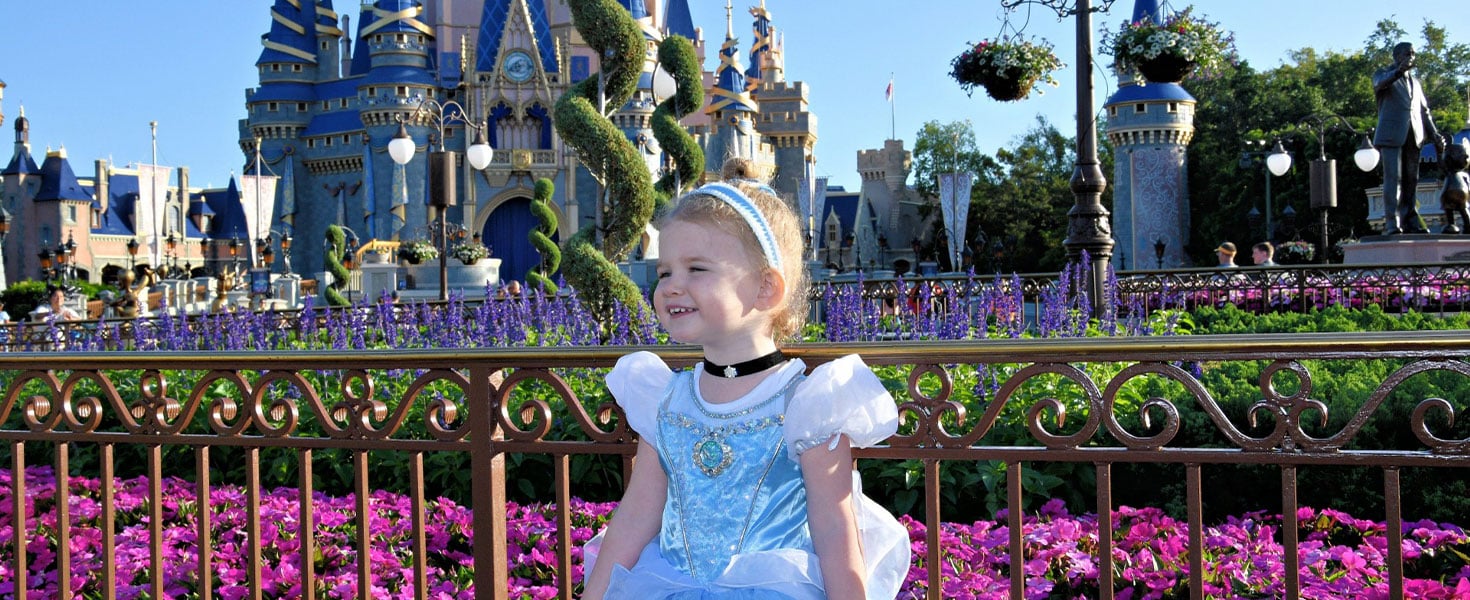 Little girl in cinderella costume in front of Disney's Magic Kingdom castle