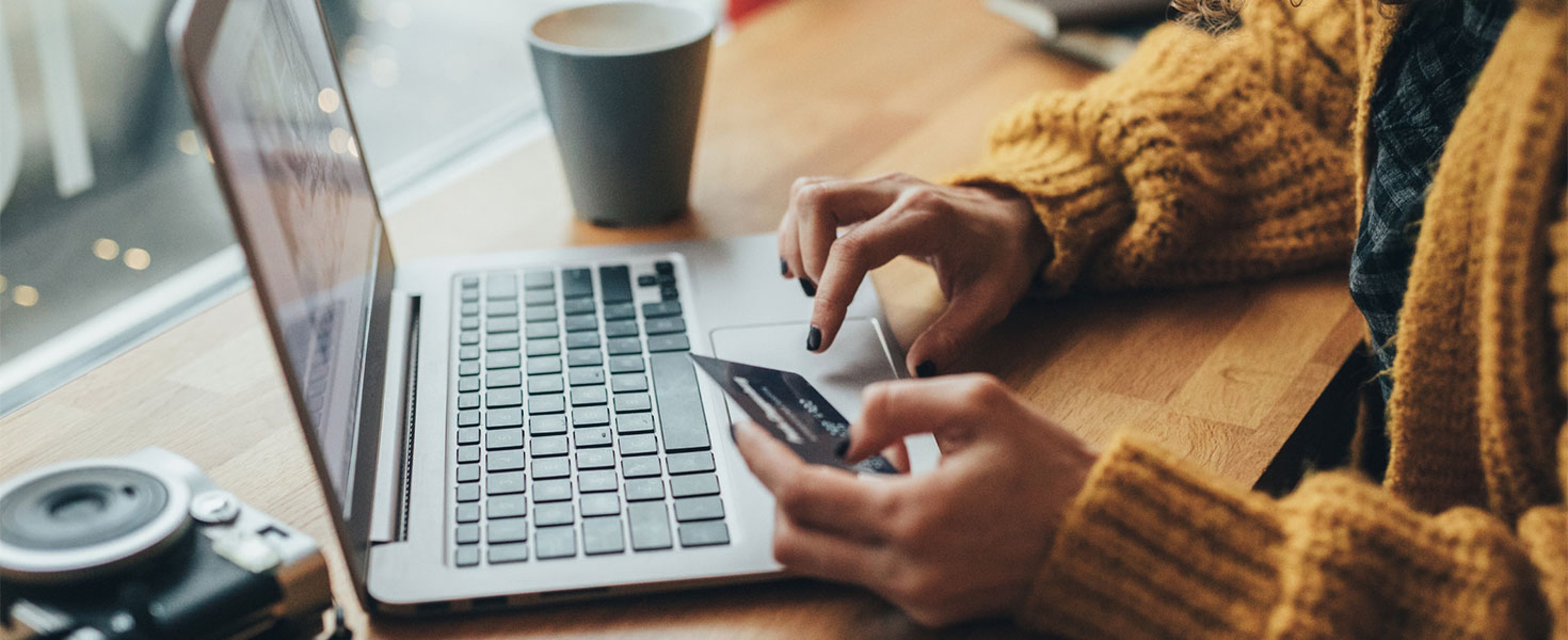 person using laptop with credit card in hand