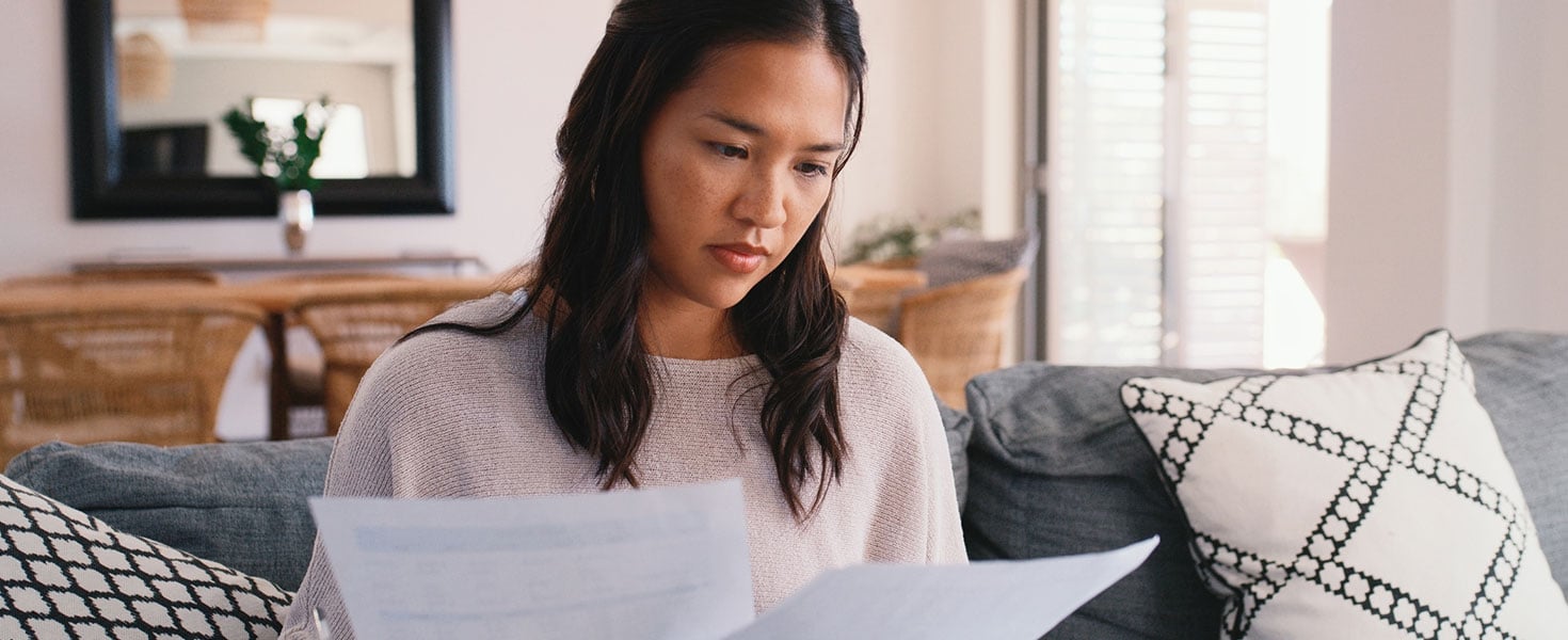 Woman, relax and reading documents at house with financial planning, mortgage insurance and taxes report. Girl, review policy and paperwork of banking balance, loan application and investment funding Credit:shapecharge