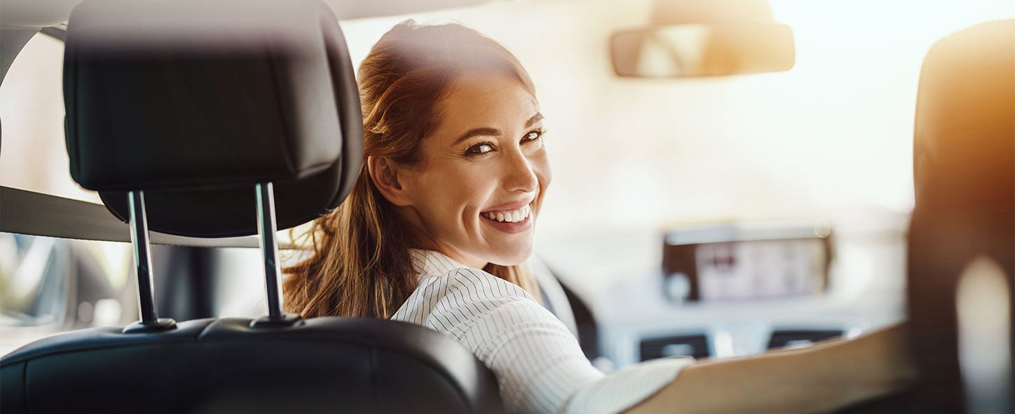 woman in driver's seat looking back over shoulder
