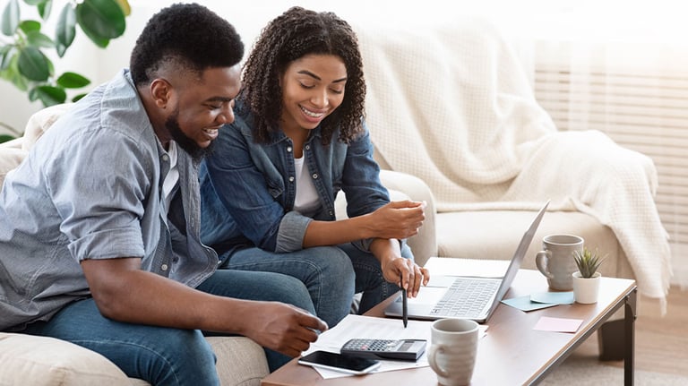 Couple looking at documents with laptop and calculator 