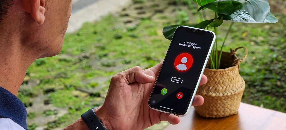 man holding phone as suspected spam calls