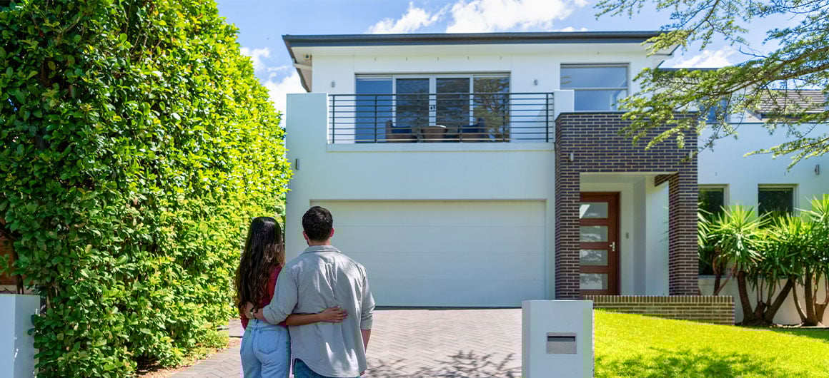 man and woman looking at outside of house