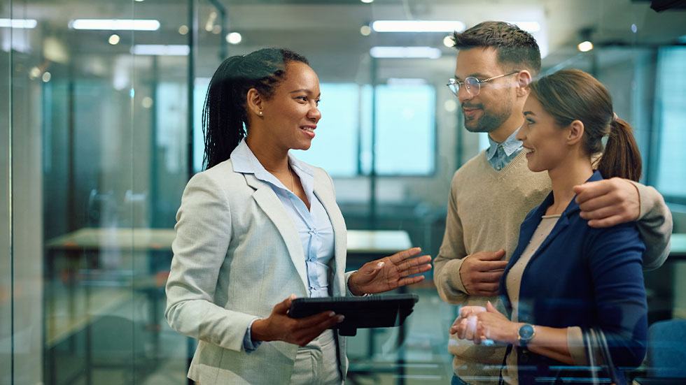 Couple meeting with banker who is holding a tablet