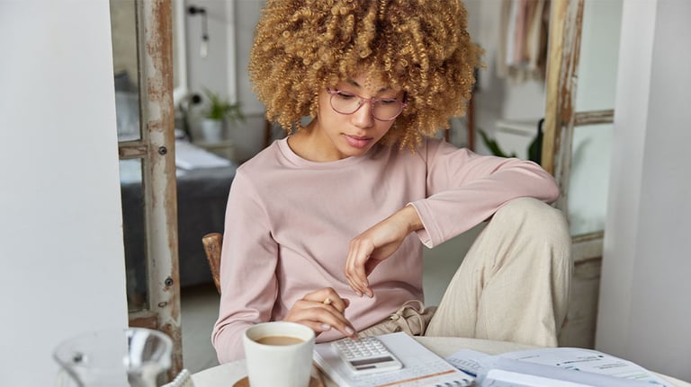 girl sitting at table using calculator