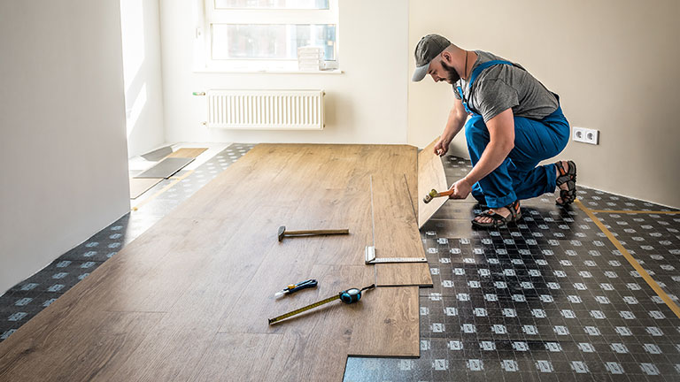 Construction worker suffering back ache lifting work carrycot By Antonioguillem