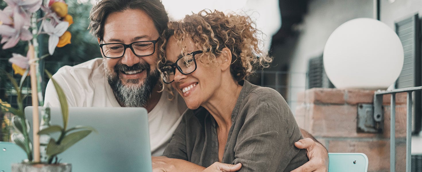 man and woman looking at laptop together