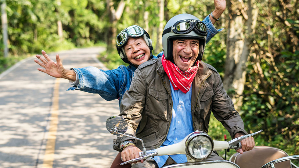 senior couple riding electric scooter