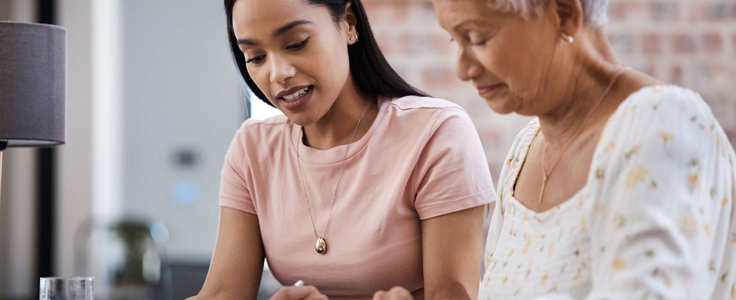 young woman looking at document with older woman