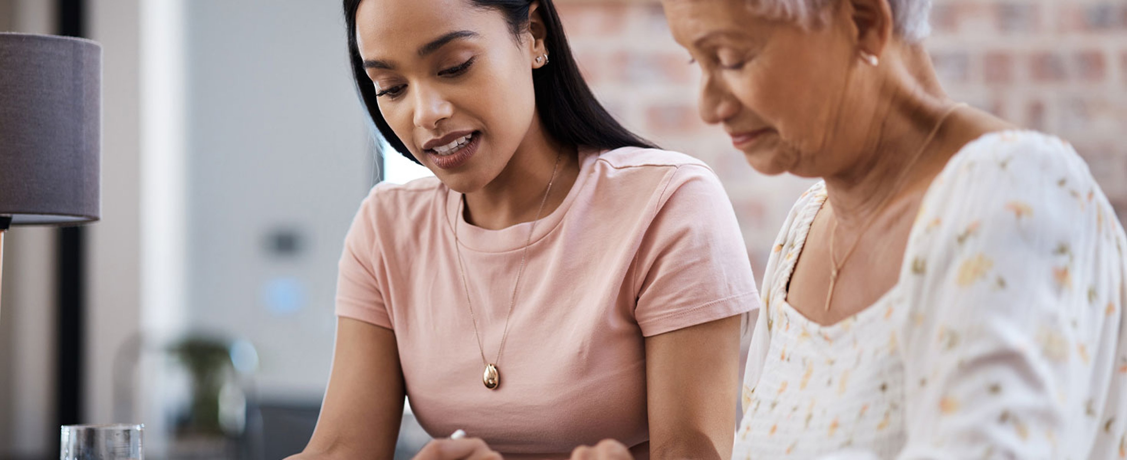 young woman looking at document with older woman