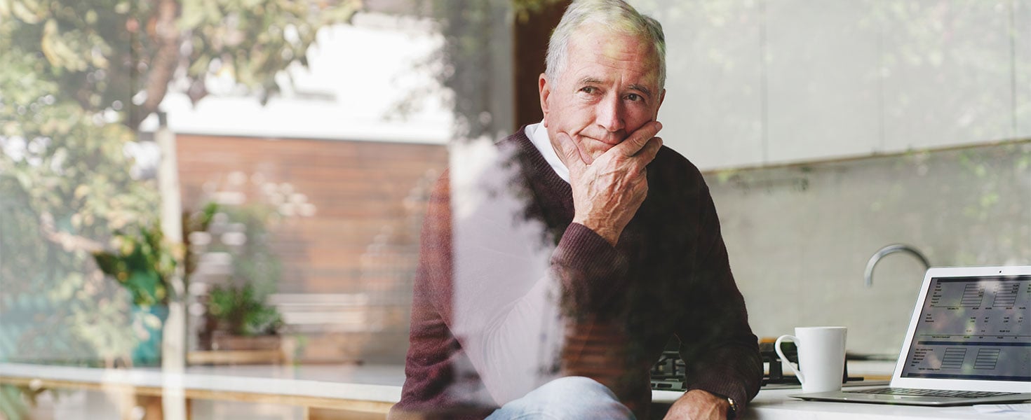 Man sitting with laptop, looking out window