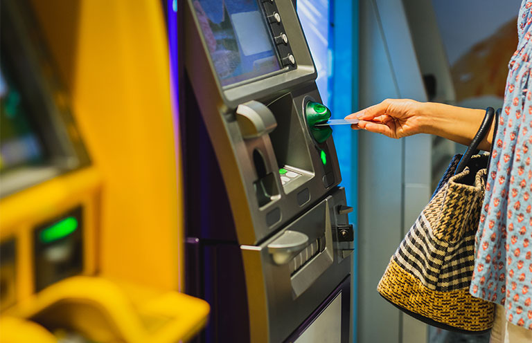 person inserting card into atm