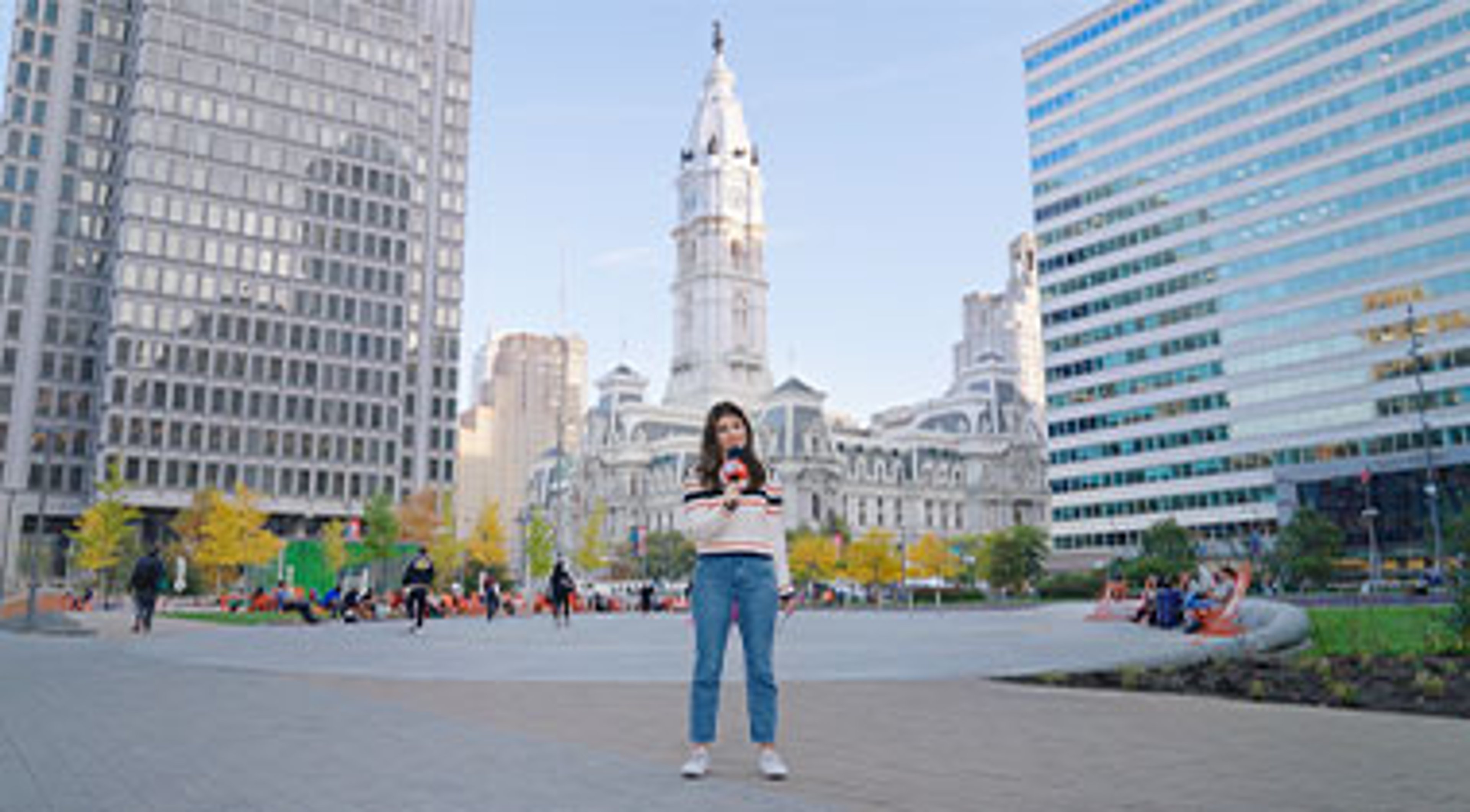 Woman holding Policy Pop Quiz microphone, downtown Philadelphia 