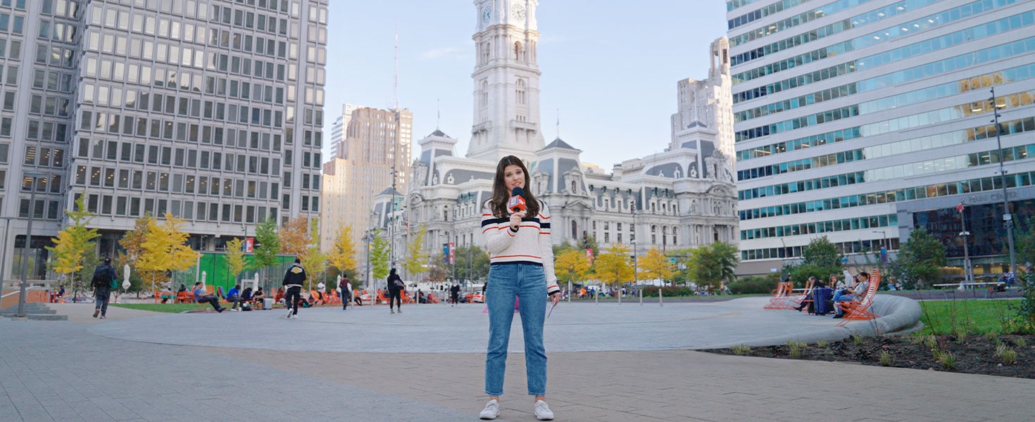 Woman holding Policy Pop Quiz microphone, downtown Philadelphia