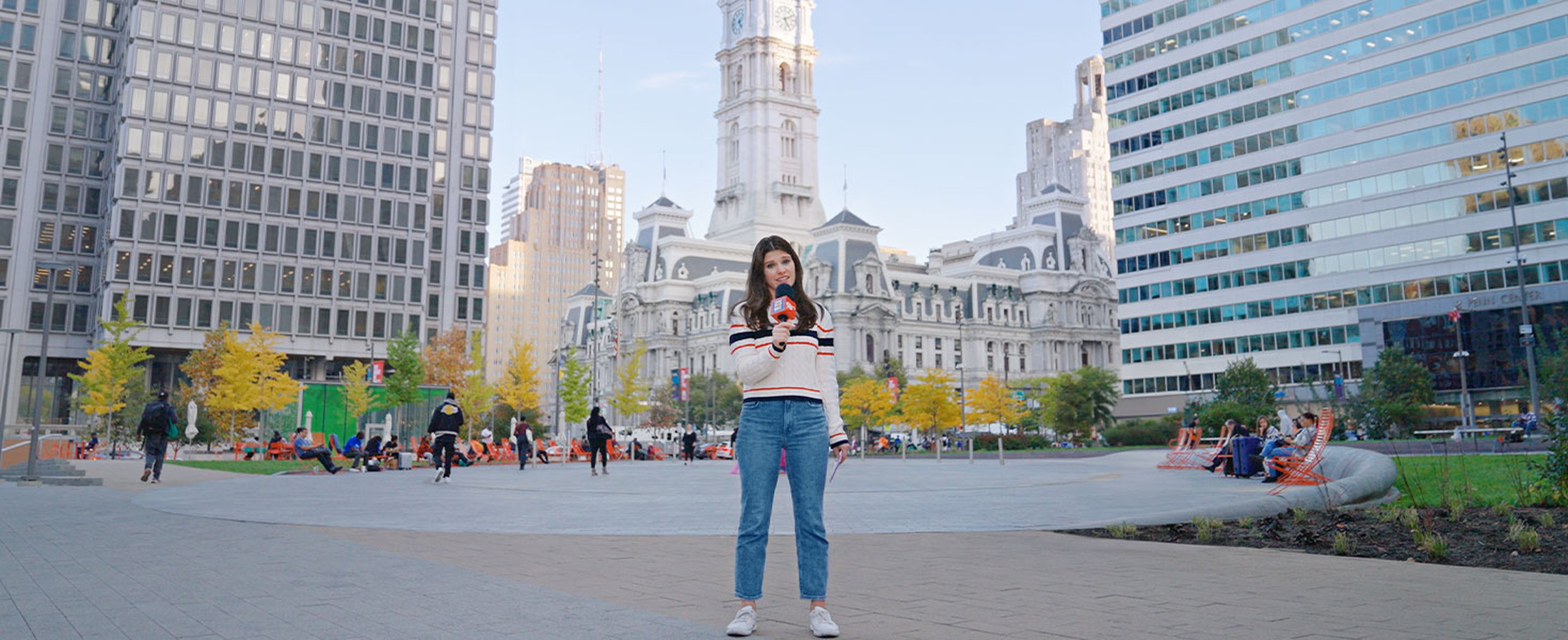 Woman holding Policy Pop Quiz microphone, downtown Philadelphia 
