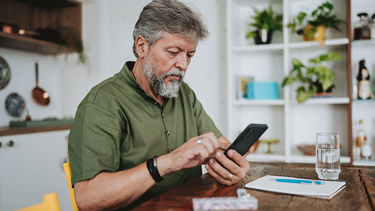 Elderly man checking medical prescription on smartphone