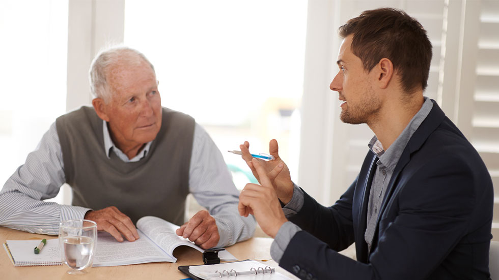 elder man sitting with a tax worker