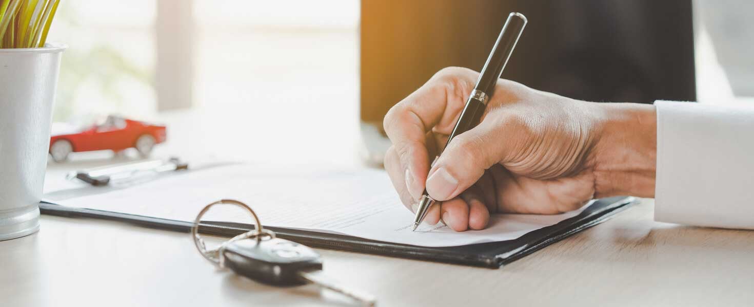 Hand signing papers with a pen