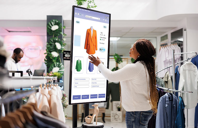 woman using interactive touch screen monitor in clothing store