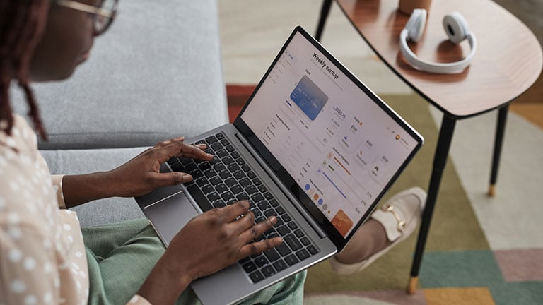 High angle view at young African-American woman using laptop with banking service on screen, copy space Credit:SeventyFour