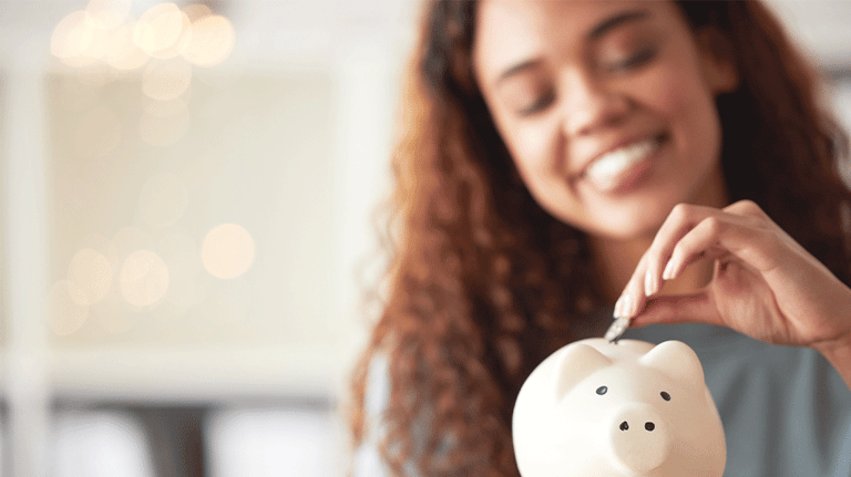 Woman putting coin in piggy bank
