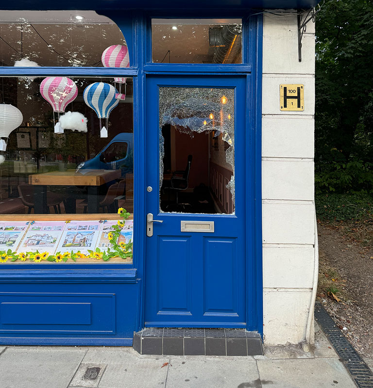 Smashed door window in an estate agents in Woodford, north east London; Credit: Tim Parker