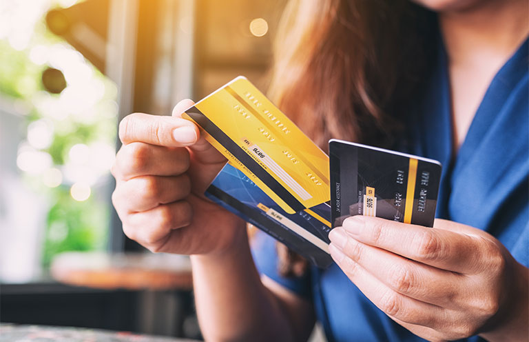 woman holding three different credit cards