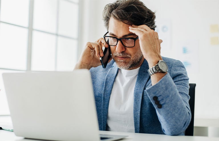 man concerned, on phone and laptop