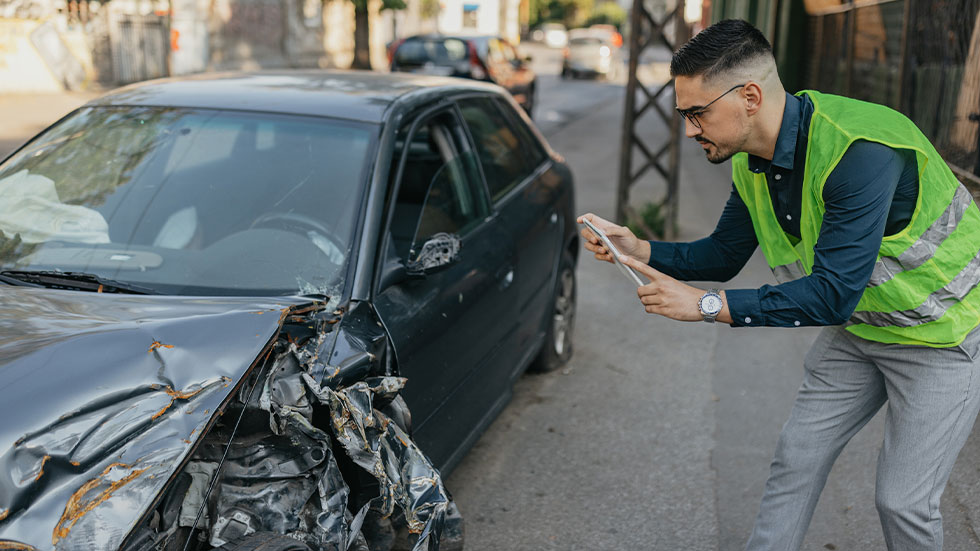 man taking photo of crashed car