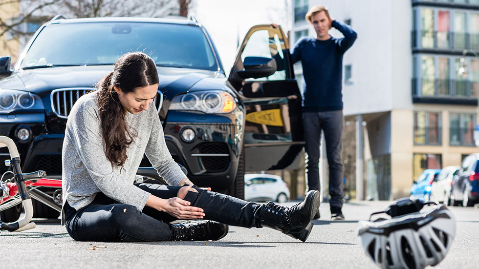 Woman riding bicycle gets hit by car