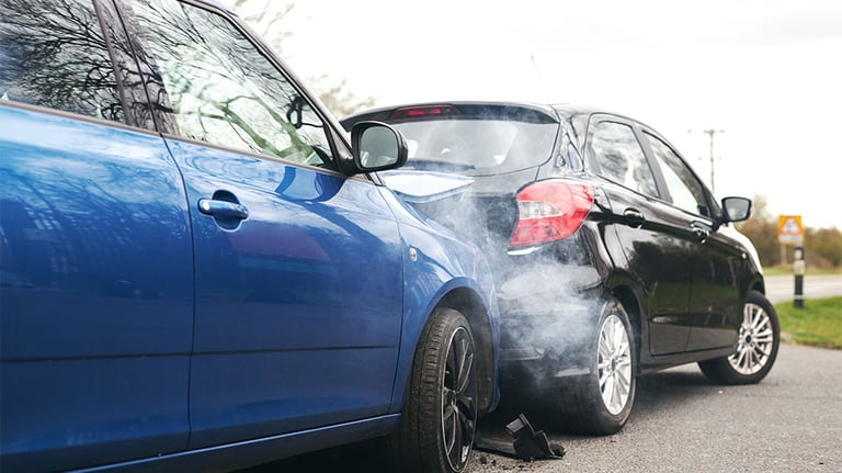 blue car crashing into rear of black car