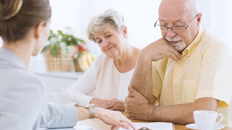 older couple signing documents