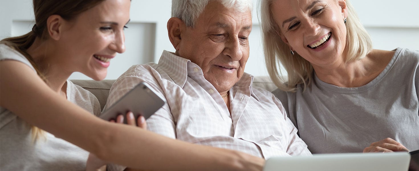 older couple looking at screen with daughter