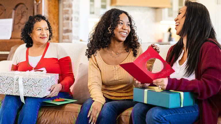 Enjoying Christmas together, the mother leans back to laugh after reading a funny remark from her daughter in the card. Credit:SDI Productions