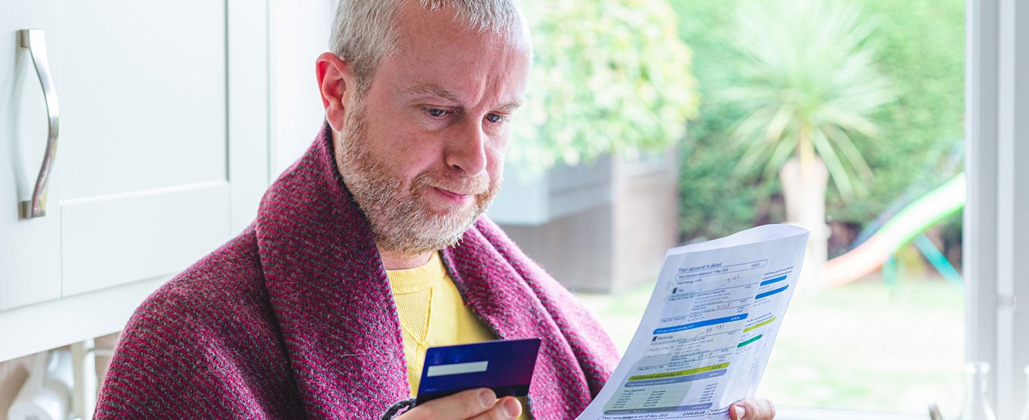 Man looking at credit report and his credit card