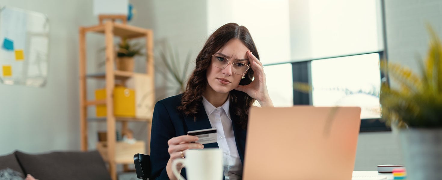 woman using laptop and holding credit card